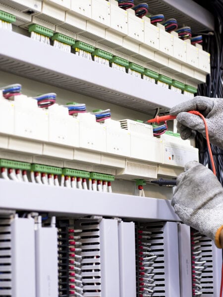 Electrical engineer tests the operation of the electric control cabinet on a regular basis for maintenance.