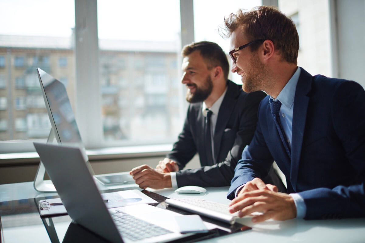 Businessman and his colleague looking at computer monitor